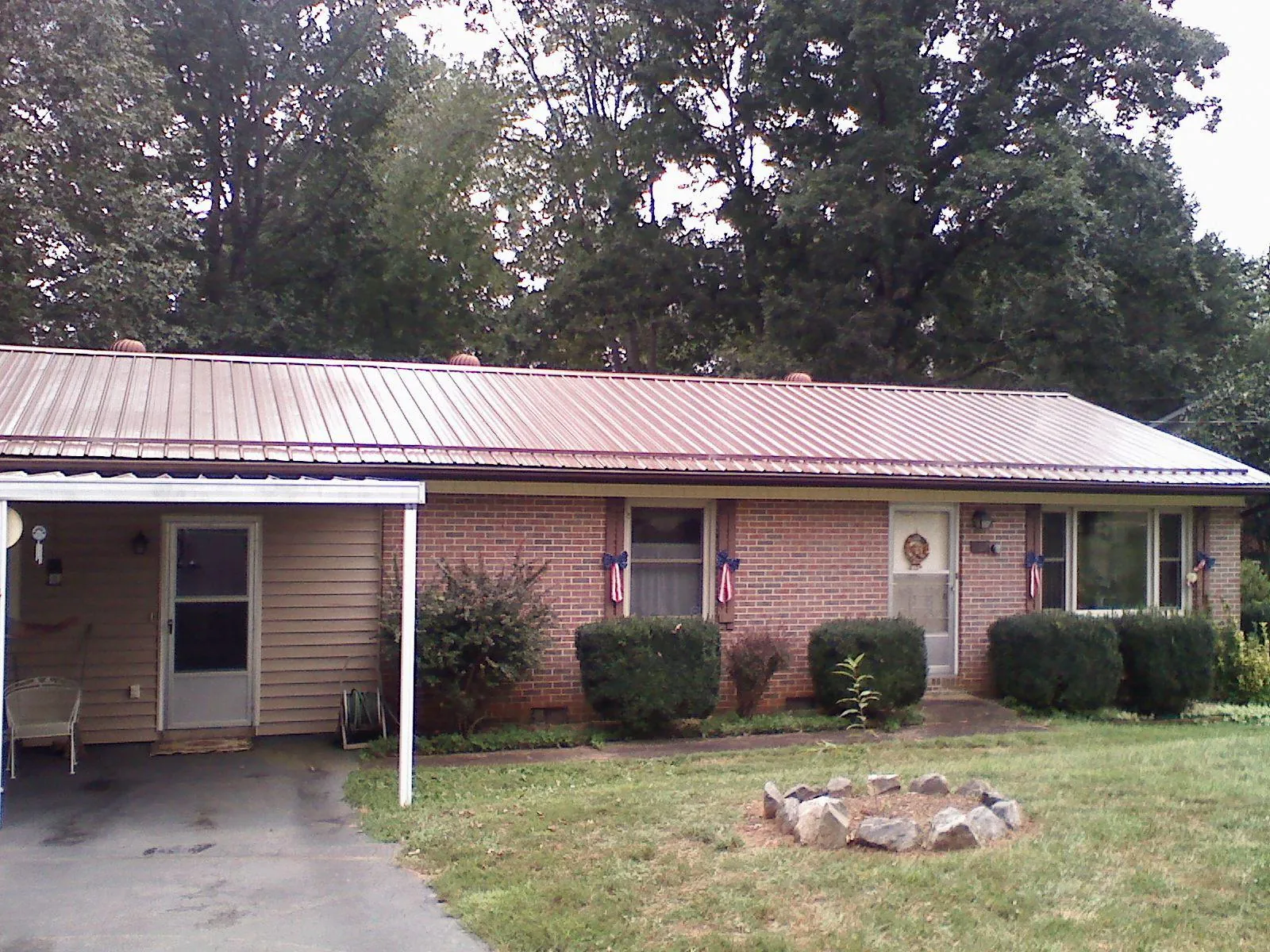 Bronze metal roof and carport on a brick ranch home — Roof Repair work by our crew in Hartfield